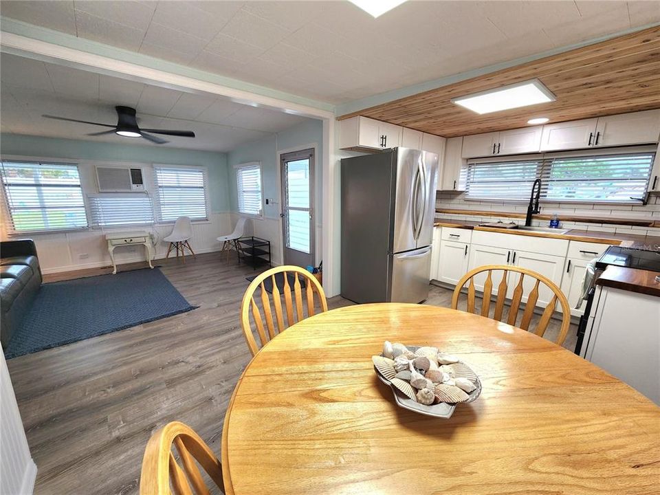 dining room open to the living room with new ceiling fan.  Front door is in the living room