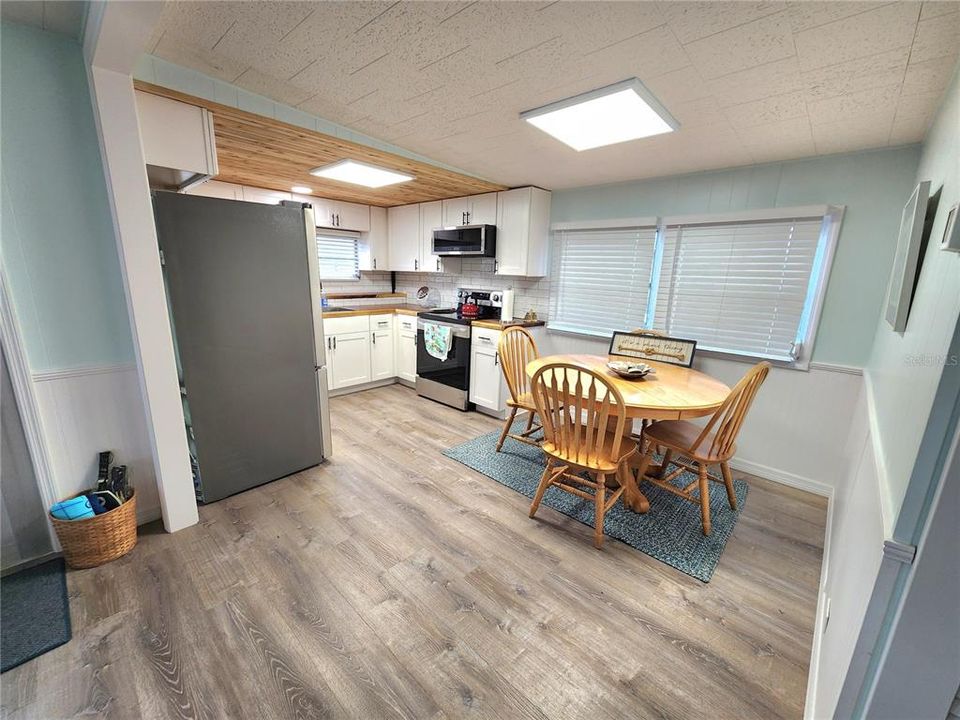 lNotice the wood ceiling in the kitchen, over the range microwave, stainless steel appliances, new flooring, paint and window treatments.