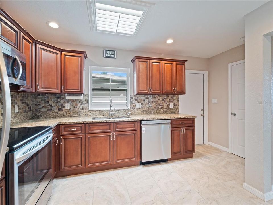 Kitchen has skylight & it's own door to exterior