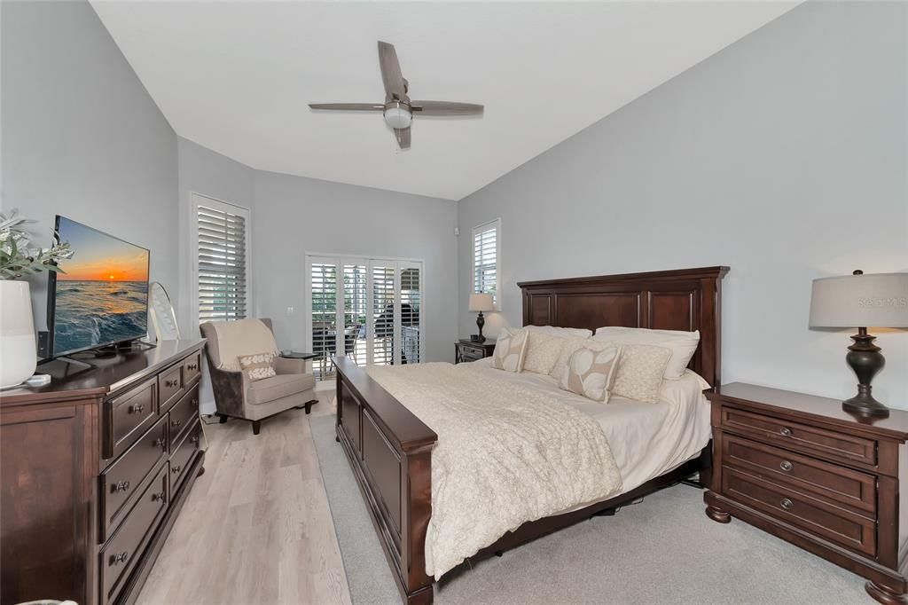 It's time for bed in this gorgeous master bedroom with a sliding glass door to the covered lanai and pool area