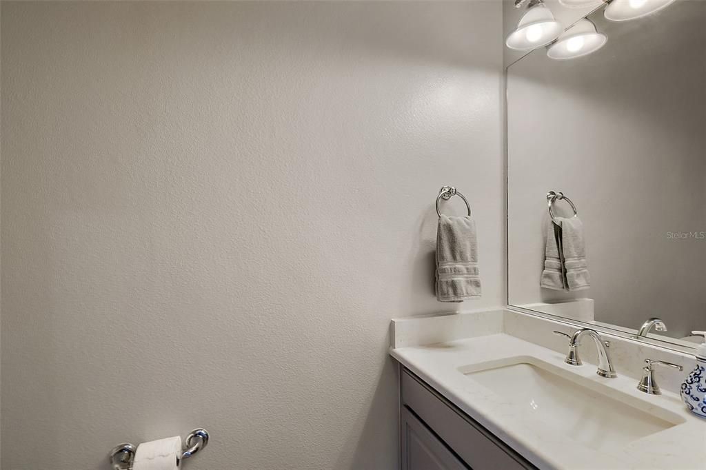 Half bath for guests.  Updated quartz counters, lighting and fixtures.