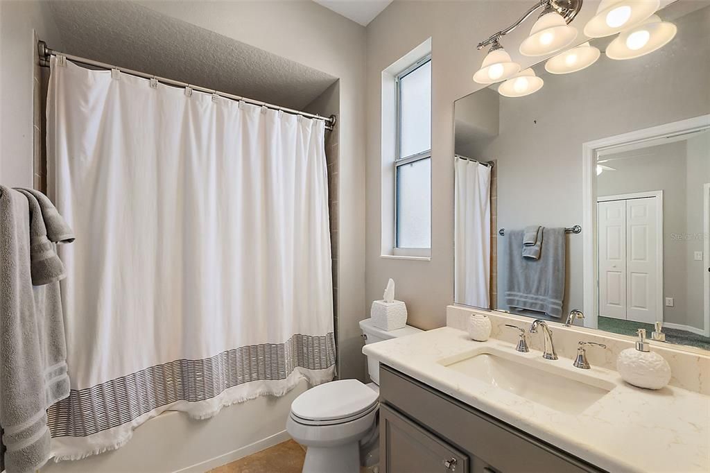 Jack & Jill bath with updated quartz counters, lighting and fixtures.