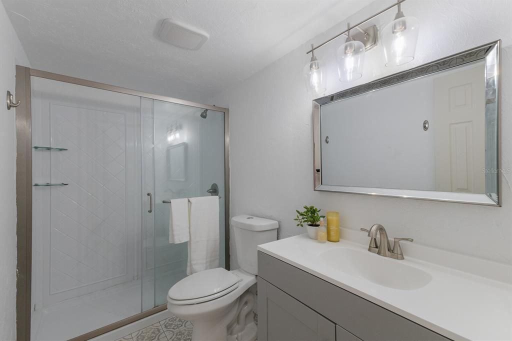 Well appointed main bathroom with walk-in shower and new glass doors