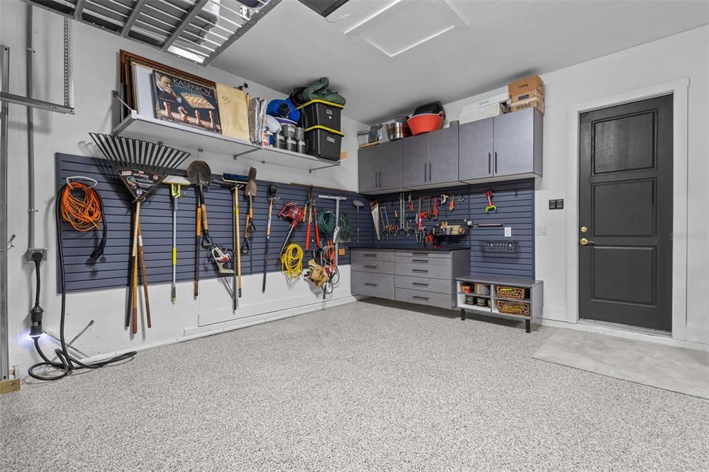 Cabinets and Storage racks in garage that has epoxy floors