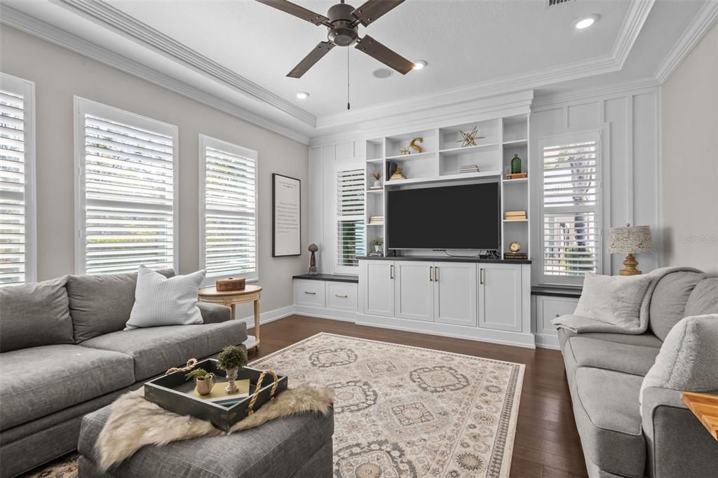 Bonus room in rear of home with tray ceilings and built in entertainment center