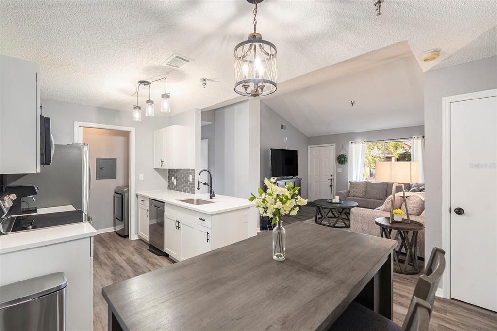 Quartz kitchen countertop, modern tile backsplash, white shaker cabinets, and stainless steel appliances!