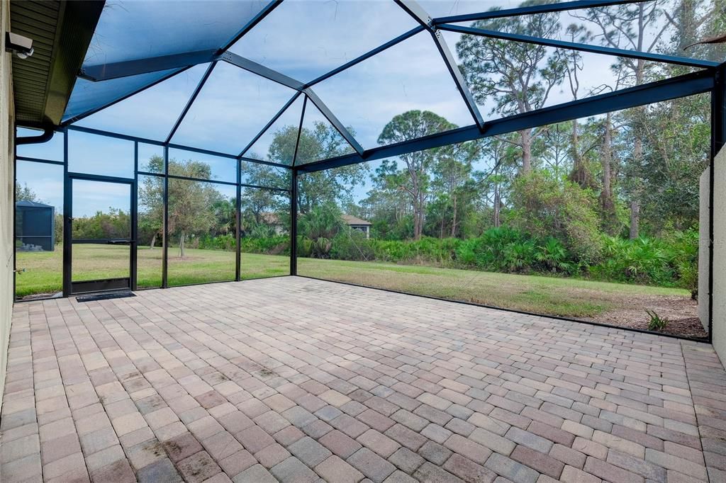 Enclosed Caged Lanai w/pavers with view to woods