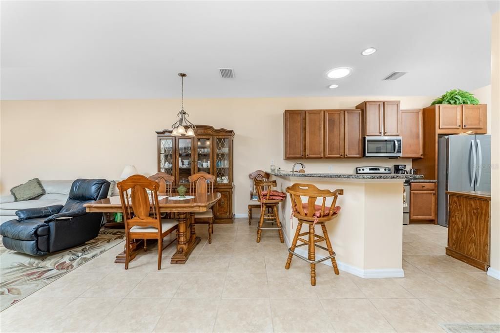 The living and dining area has tiled flooring and a volume ceiling.