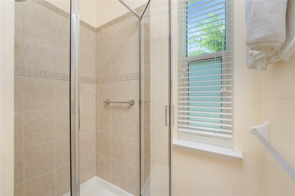 The master bathroom has a nice step in shower with a glass door.