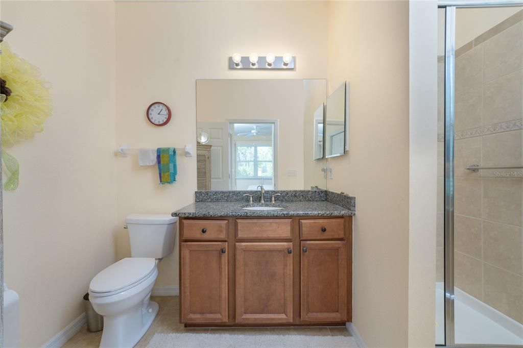 The master bathroom features tiled flooring and a wood vanity with a granite counter top for plenty of storage.