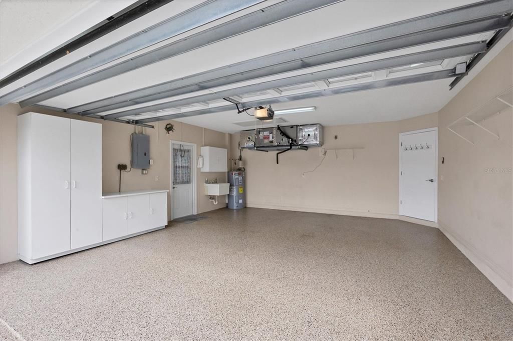 Garage with epoxy floor, storage, and laundry tub