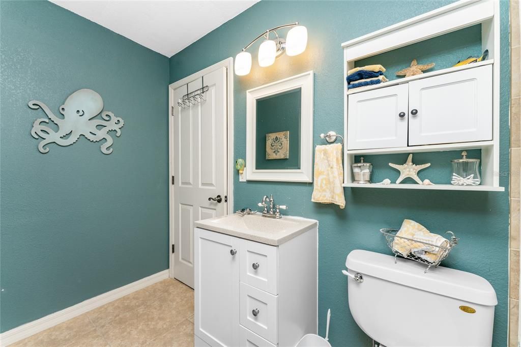 The guest bathroom has a nice raised height vanity with a cultured marble top and tiled flooring.