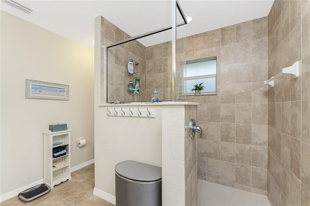 This master bathroom features a beautiful Roman shower, linen closet and tiled flooring.