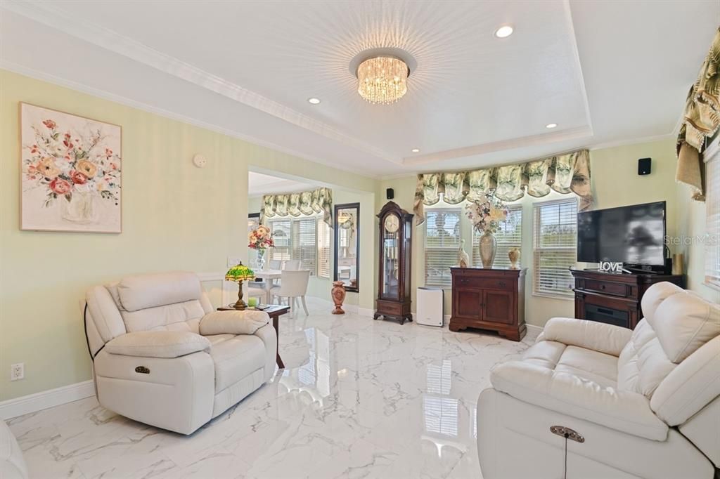 Living room with bay window and tray ceilings