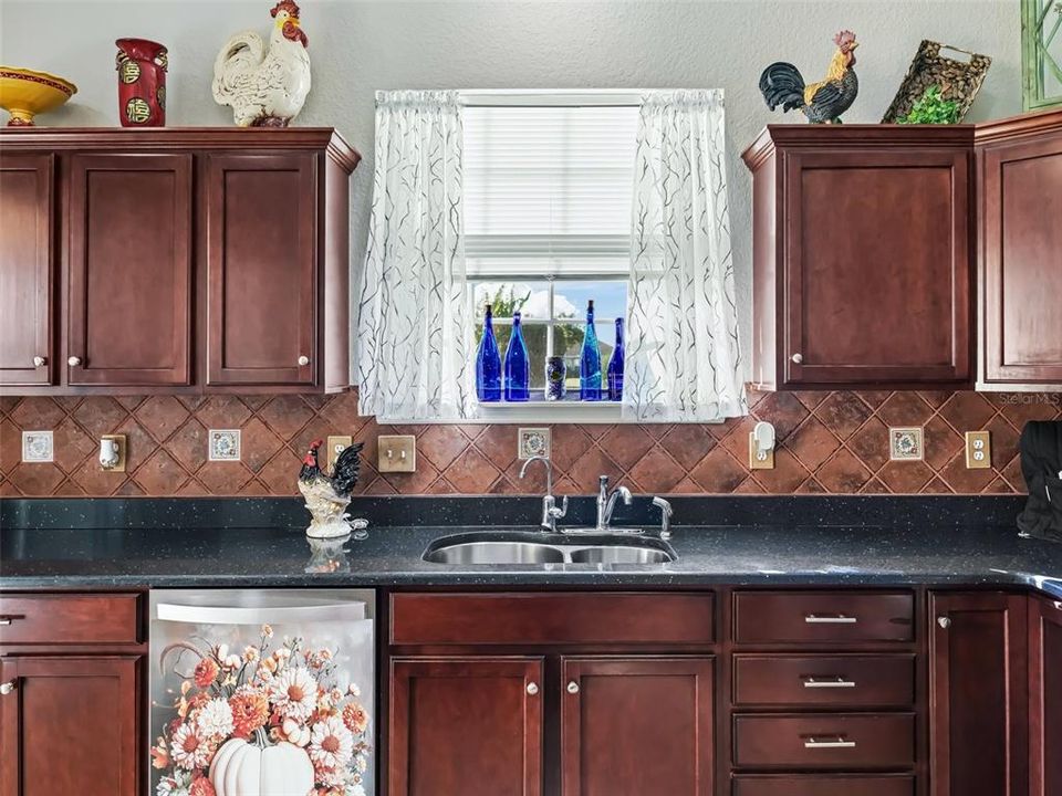 Kitchen w/Quartz countertop & Tile backsplash