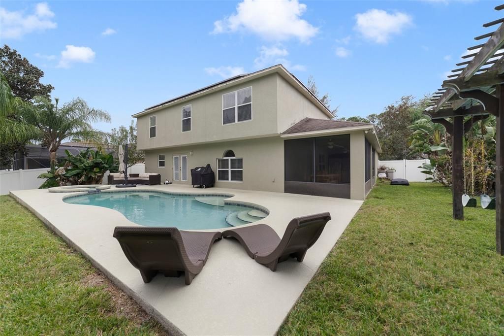 The backyard is an entertainer’s dream with a SCREENED LANAI on the side of the home perfect for weekend cookouts after spending the day splashing in your heated salt water pool.