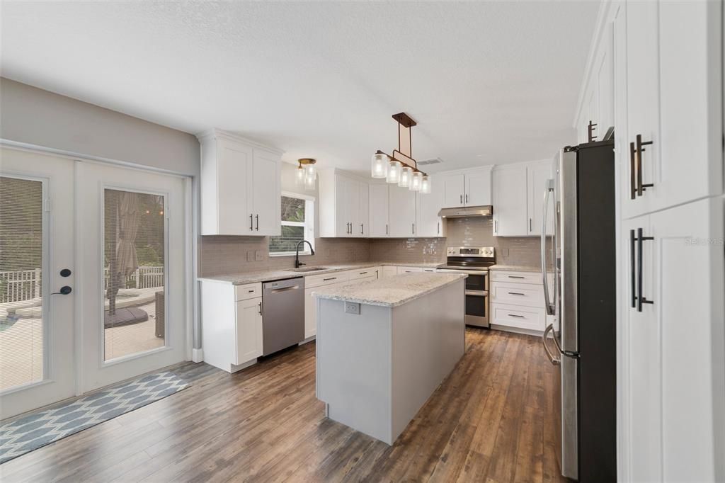 The kitchen, casual dining and living area are all open to each other with large windows and French doors that let the NATURAL LIGHT pour into the space.