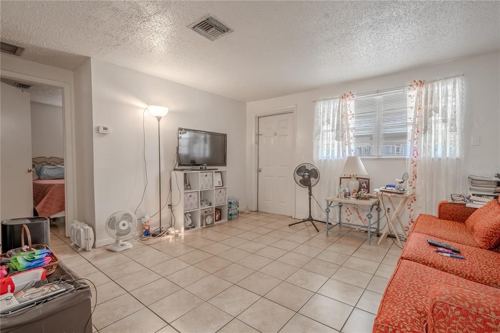 UNIT A: Living room features ceramic tile flooring a neutral tones