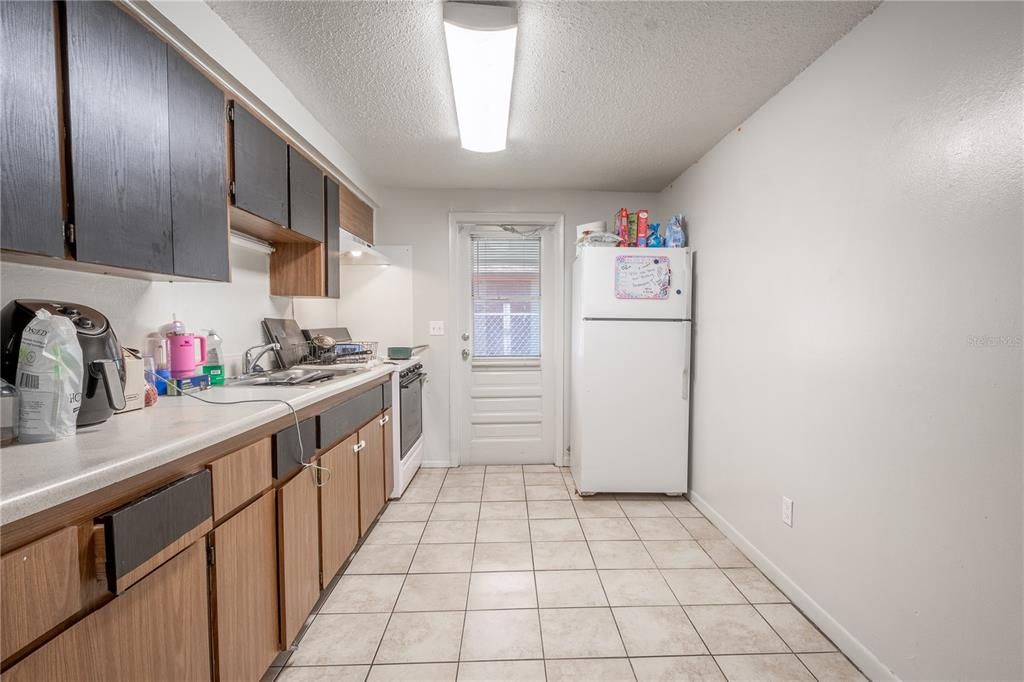 UNIT B: The kitchen features solid countertop, cabinets and ceramic tile flooring.