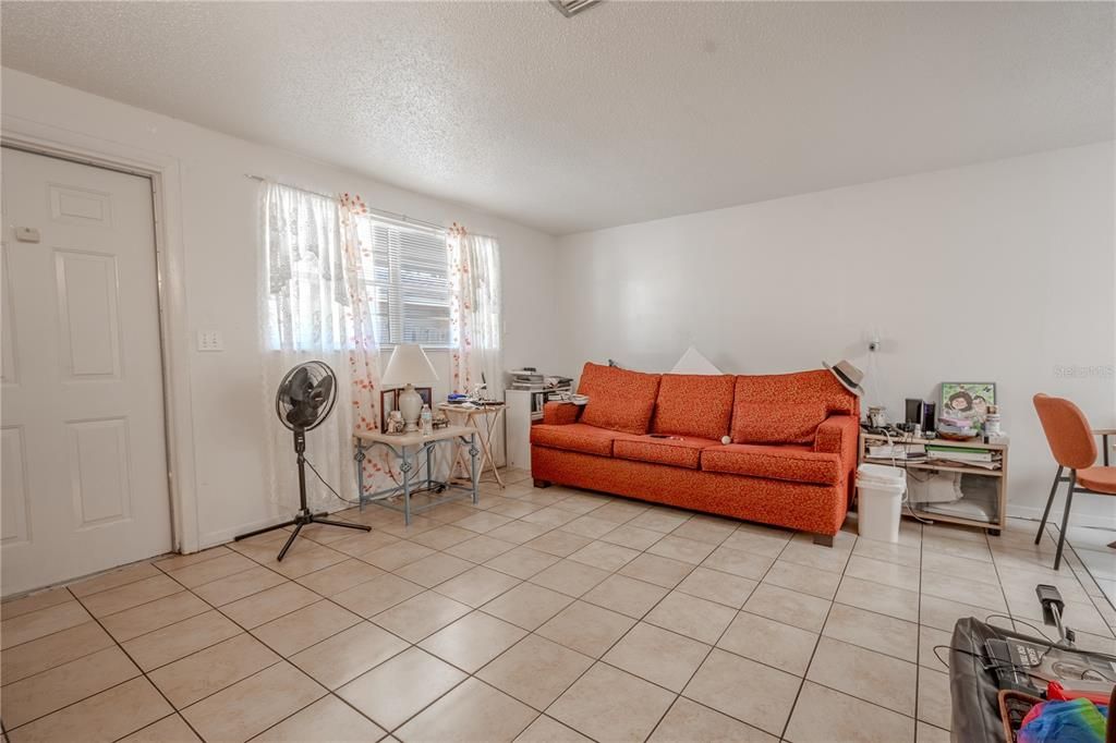 UNIT A: Living room features ceramic tile flooring a neutral tones