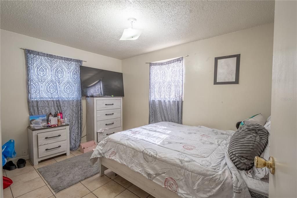 UNIT B: 2nd bedroom ceramic tile flooring, a ceiling fan with light kit and a built-in closet