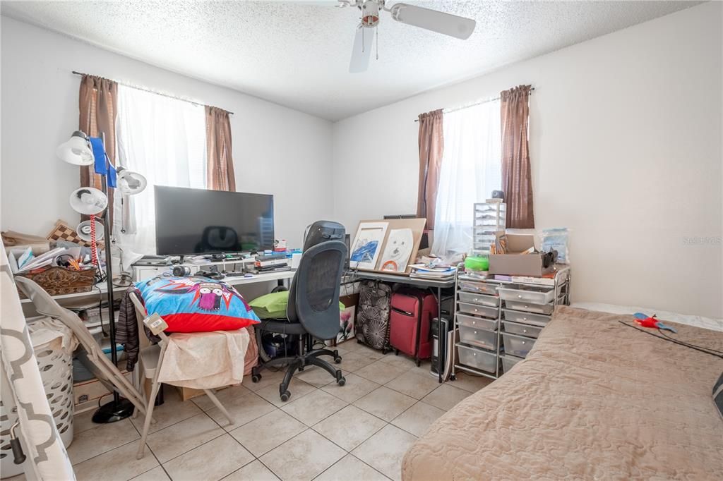 UNIT A: 2nd bedroom ceramic tile flooring, a ceiling fan with light kit and a built-in closet