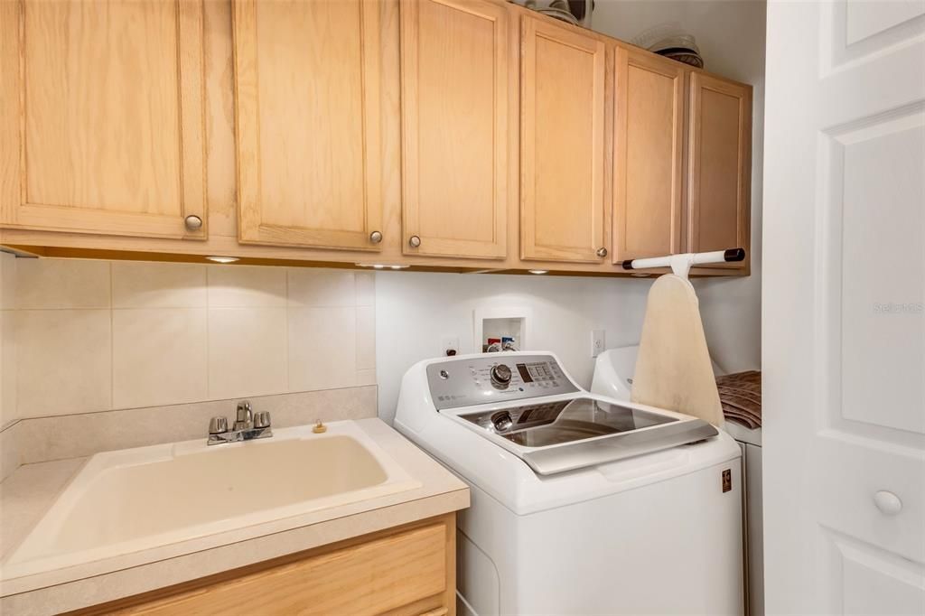 Inside laundry closet with sink and plenty of storage