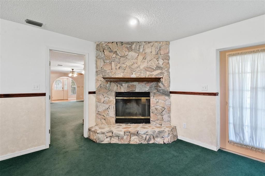 Primary Bedroom with a Stone Wood-Burning Fireplace