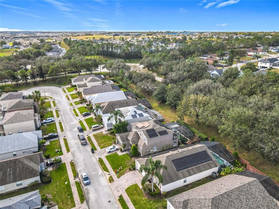 An aerial view showing sidewalks in the front and a treelined street in the back.