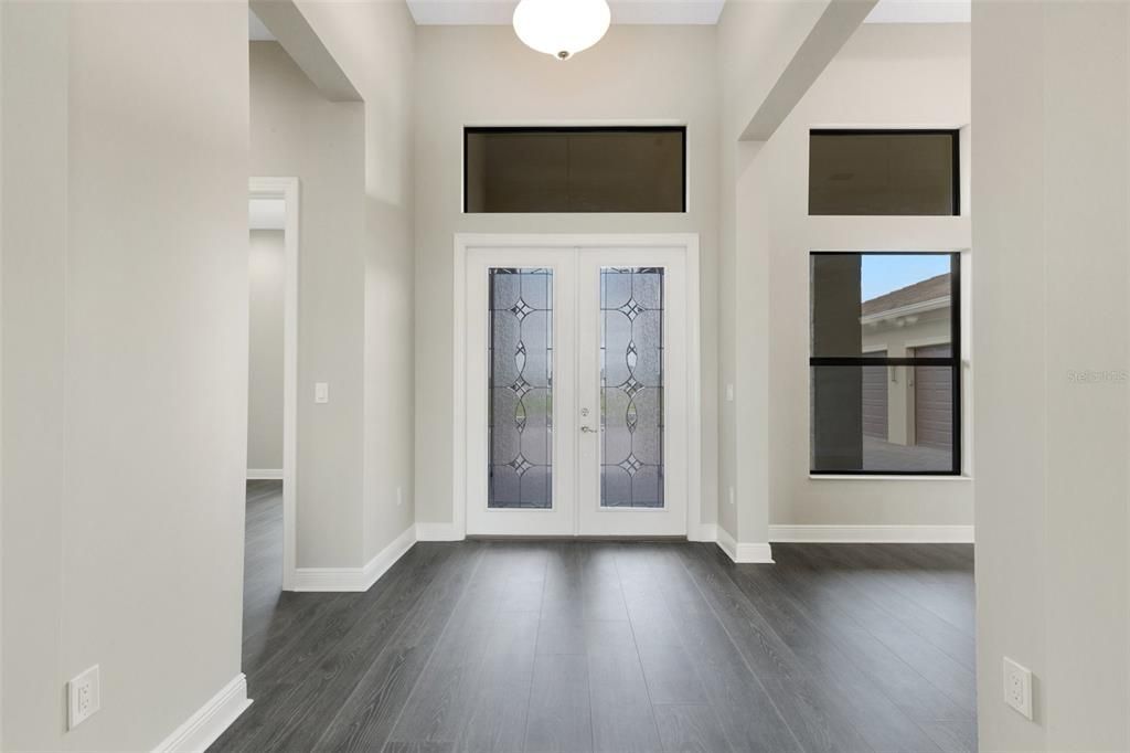 Grand double glass door entry into the foyer.