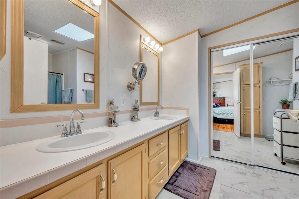 Adjacent Primary Bathroom with dual sinks and built in closet for extra storage