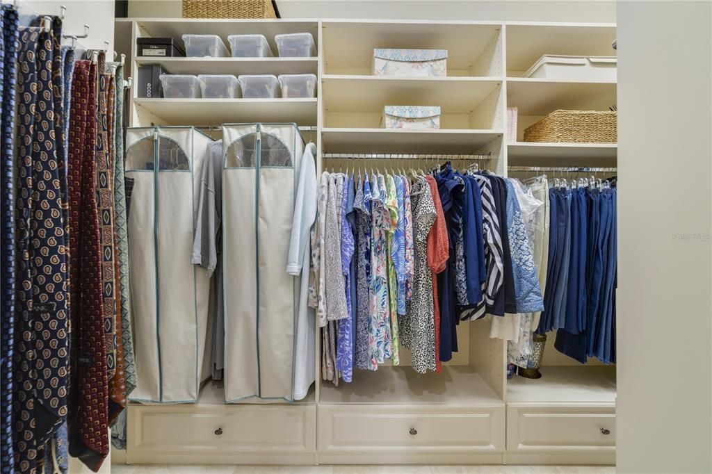 Primary walk in closet with custom built in organizers