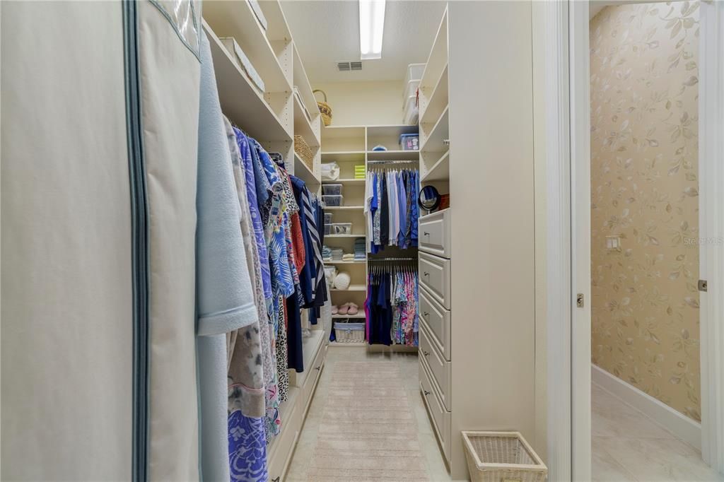 Primary walk in closet with custom built in organizers