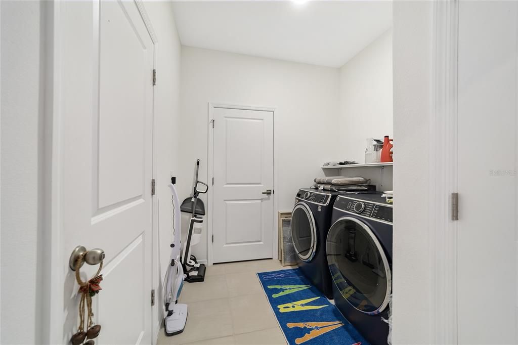 laundry room with access door to additional storage room