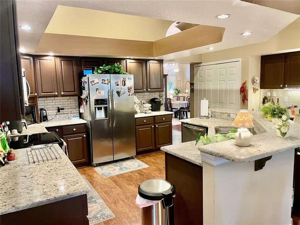 KITCHEN SHOWING RECESSED CELING, BREAKFAST BAR, BEAUTIFUL ESPRESSO CABINETS AND LIGHT GRANITE