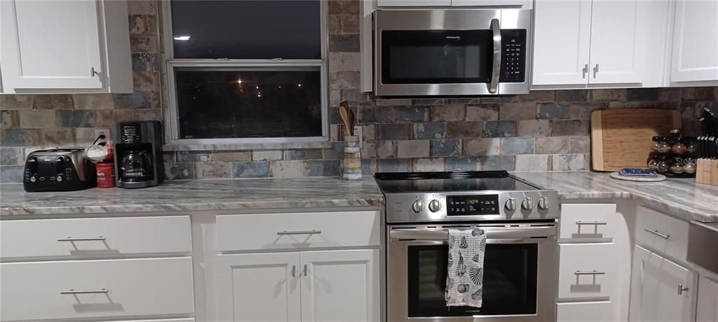 granite countertop, tiles on the wall that matched with floor color, upscale stainless-steel appliances and equipments