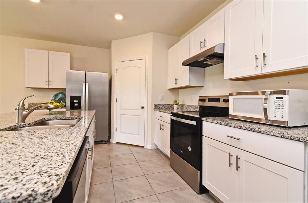 Wood shaker cabinets, granite counter tops, and a large walk-in pantry