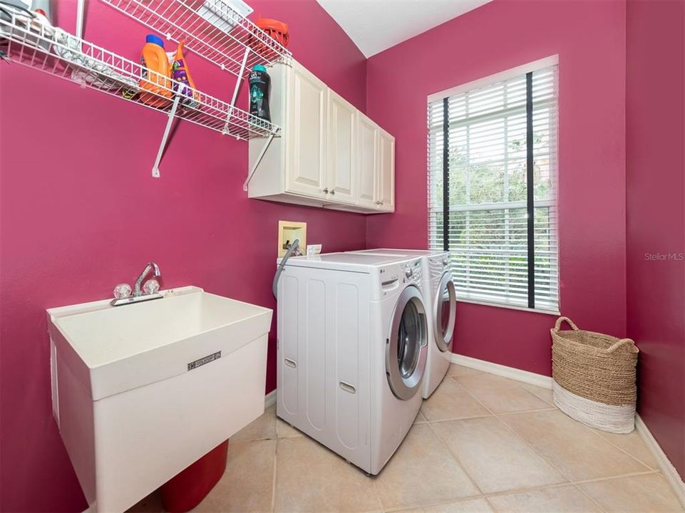 The large laundry room includes storage and utility sink