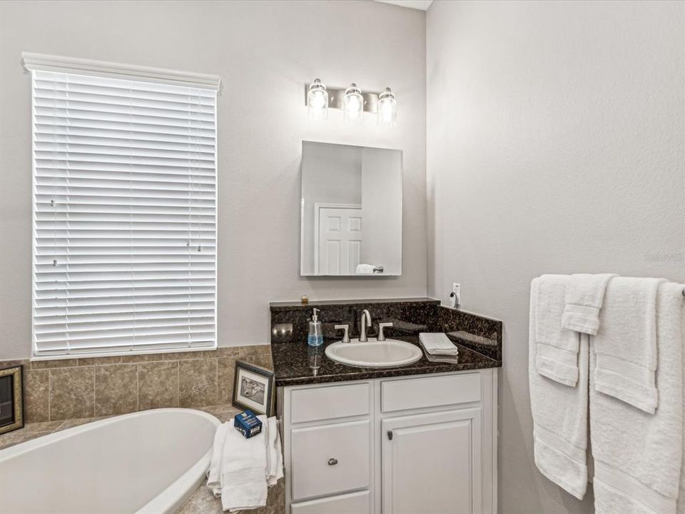 Separate vanities with cabinets keep organization and convenience at the forefront of this bathroom design.