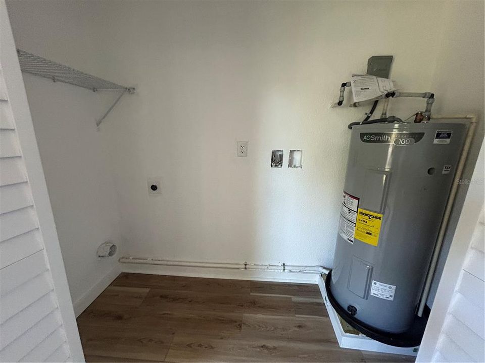 Laundry closet with new water heater in primary