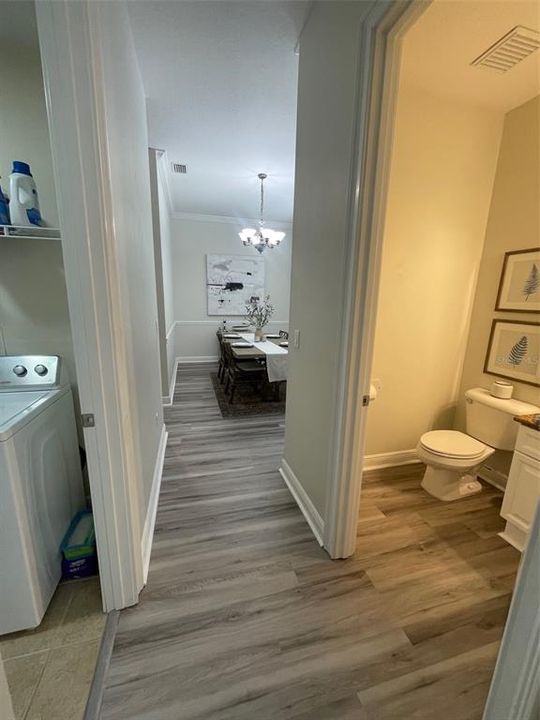 downstairs hallway leading to dining room with half bath and laundry