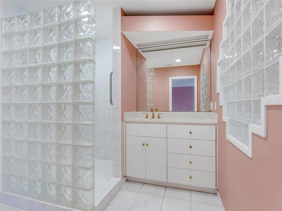 The second ensuite bathroom features a private vanity and fully tiled glass block shower.