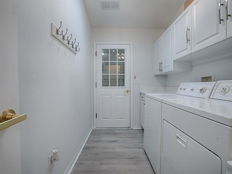 WHAT A SPACIOUS LAUNDRY ROOM! LOTS OF CABINET SPACE, BUILT-IN SINK WITH QUARTZ COUNTERTOPS, AND WASHER AND DRYER DO CONVEY WITH THE HOME.