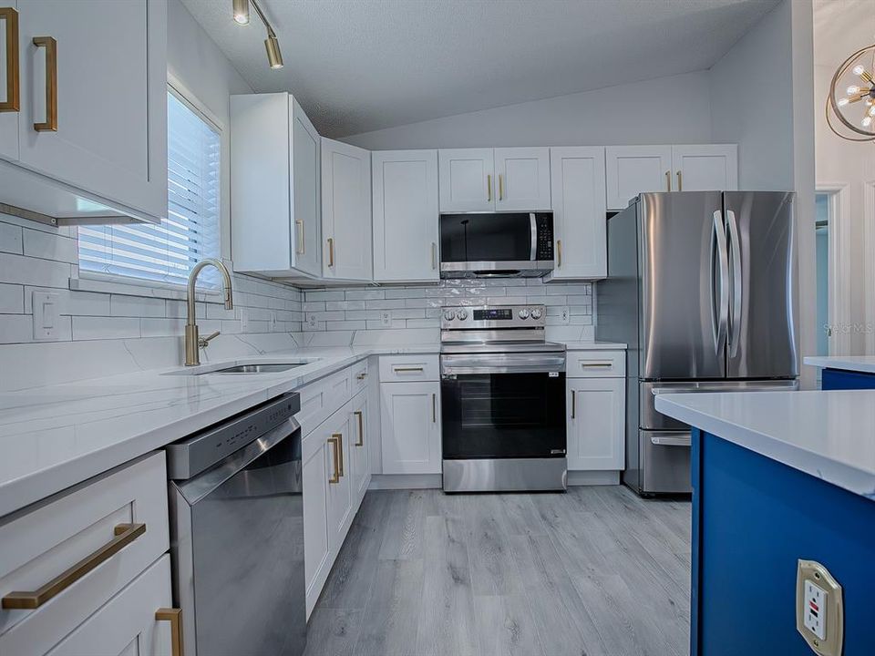 WHITE SHAKER CABINETRY WITH SUBWAY TILE BACKSPLASH.