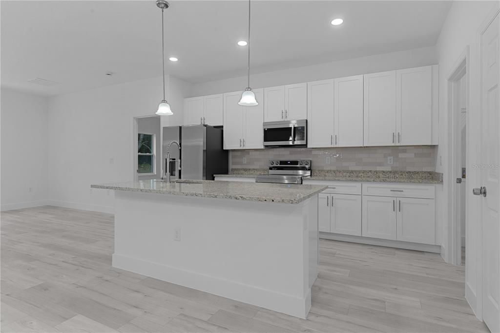 Kitchen with granite countertops, tall cabinets, and nice stainless steel appliances