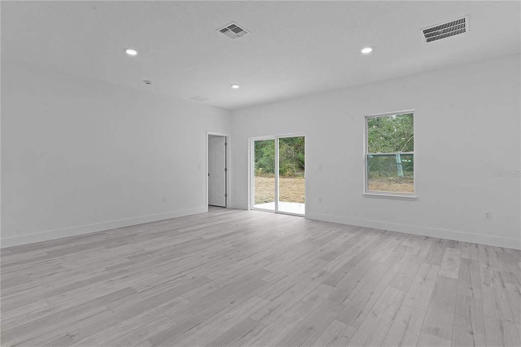 Living area from the edge of kitchen. The open door next to the slider is bedroom 4.