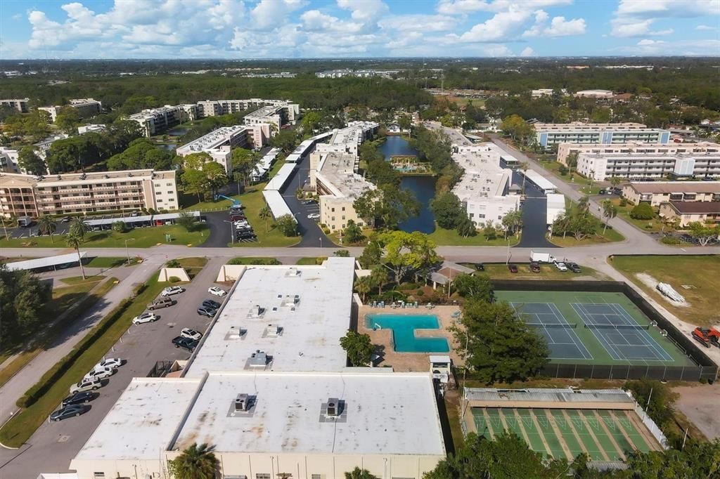 Aerial of Magnolia Sun Center (new roof in 2024). Main pool, tennis/pickleball courts and shuffle board courts at lower right in pic.