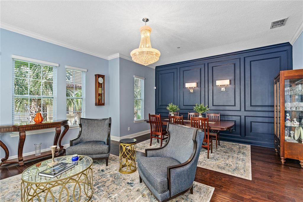 Newly installed crown molding throughout the home and beautiful accent wall with custom wainscoting and elegant sconces