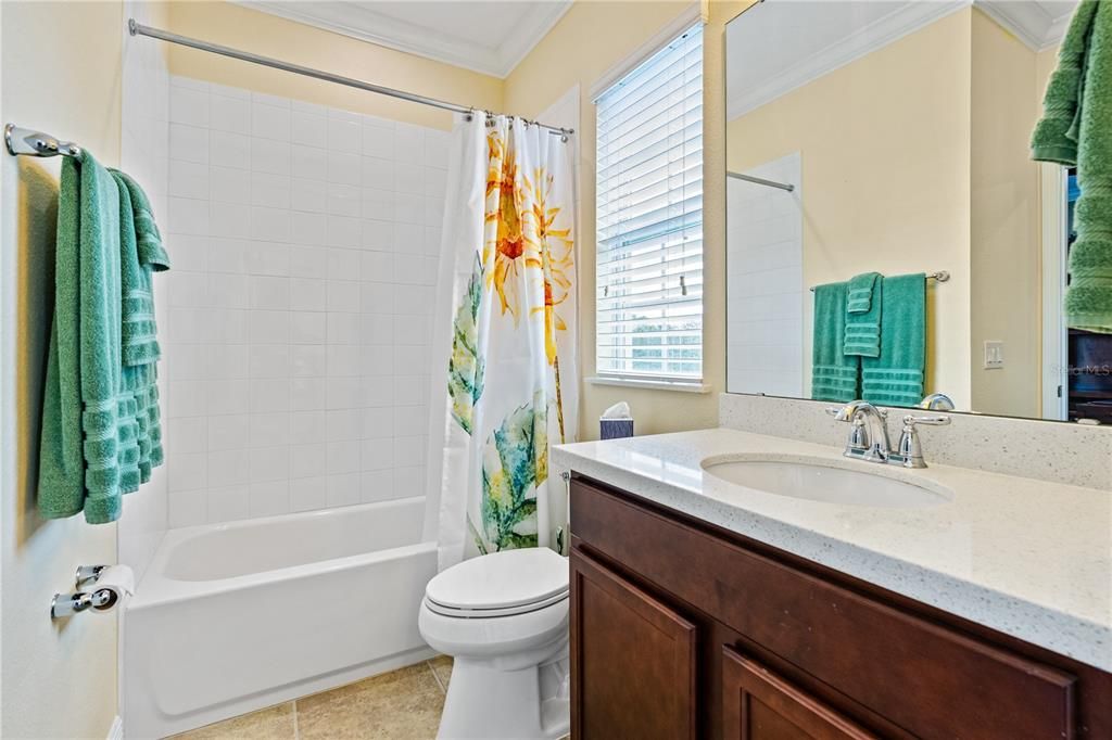 Light and bright Jack & Jill bathroom with quarts counter, new Kohler toilet and crown molding