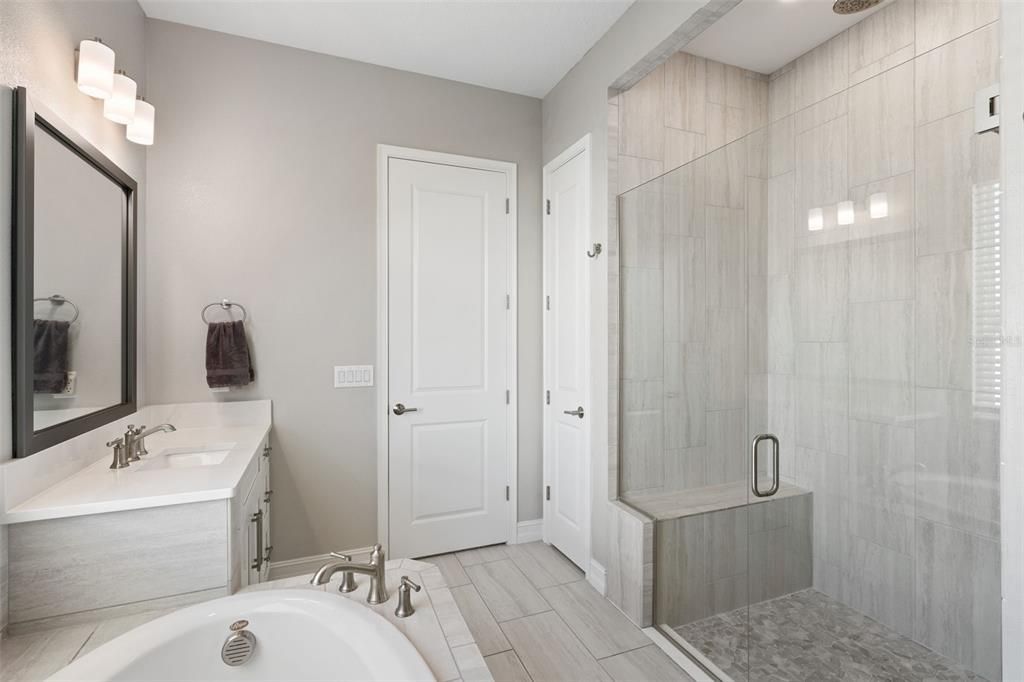 Separate shower in Primary bathroom includes a built-in bench and dual showerheads/rain shower.